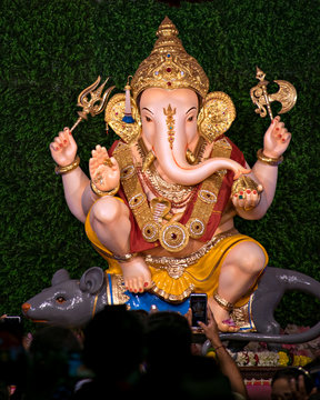 Close up portrait view of decorated and garlanded idol of Hindu God Ganesha.