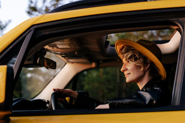 Side View of Beautiful Young Woman Driving Car. Closeup Portrait of Attractive Trendy Blonde with...