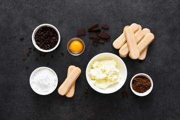 Ingredients for preparing tiramisu on a black background. Cooking process. Classic Italian dessert.
