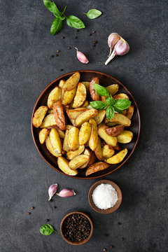 Fried Potato Wedges With Salt And Garlic In A Plate On A Black Background. View From Above.