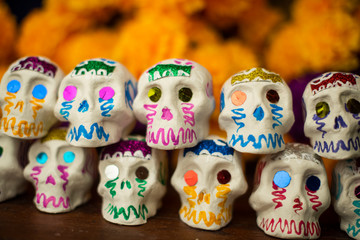 Fototapeta na wymiar Calaveritas de día de muertos hechas a mano artesanía mexicana cempasúchil tagetes erecta damasquina