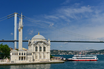 Fototapeta na wymiar Istanbul cityscape, including Bosphorus bridge and Ortakoy Mosque as seen from a passenger boat - Istanbul, Turkey