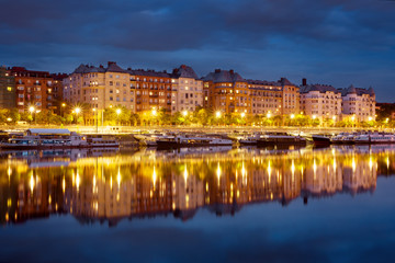 Block of of old bourgeois houses reflecting in a river by night
