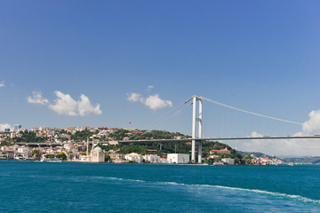 Fototapeta premium Istanbul cityscape, including Bosphorus bridge and Ortakoy Mosque as seen from a passenger boat - Istanbul, Turkey