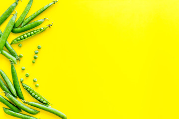Top view of green pea pods and peas on the kitchen background