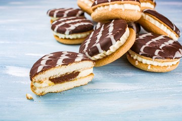 cookies with white filling and chocolate glaze on the table