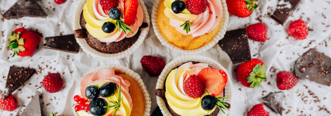 chocolate cupcakes with cream and fresh berries