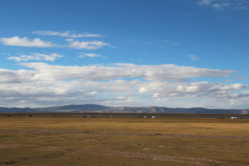 Fototapeta na wymiar View of mountains, grassland, Nomadic tents and Namtso Lake with the dramatic sky in Tibet, China