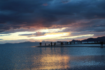 Sunset view of Namtso lake with the human silhouette and dramatic sky, Tibet, China