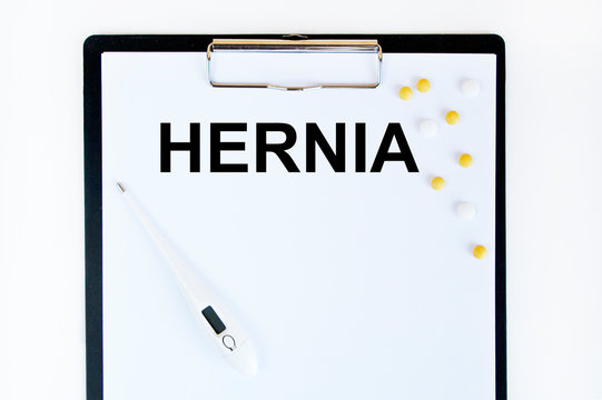 HERNIA - inscription in a notebook, next to a tablet and a stethoscope. A medical concept.