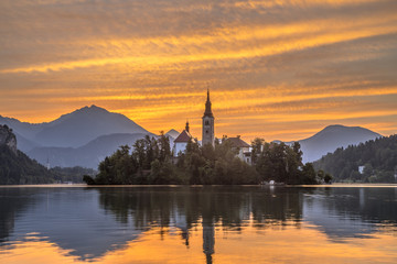 Lake bled with church during orange morning sky