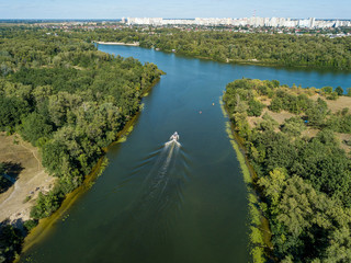 Fototapeta premium Motor boat in the Dnipro river. Sunny clear summer day. Aerial drone view.