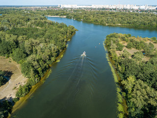 Fototapeta premium Motor boat in the Dnipro river. Sunny clear summer day. Aerial drone view.