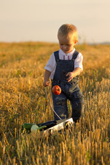 A boy in a shirt with a Belarusian ornament carries a basket of vegetables