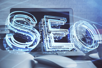 Multi exposure of table with computer and seo drawing hologram. Search optimization concept.