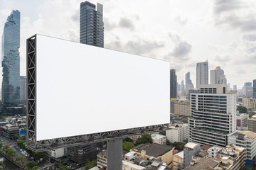 Obraz premium Blank white road billboard with Bangkok cityscape background at day time. Street advertising poster, mock up, 3D rendering. Side view. The concept of marketing communication to promote or sell idea.