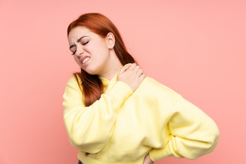 Redhead teenager girl over isolated pink background suffering from pain in shoulder for having made an effort