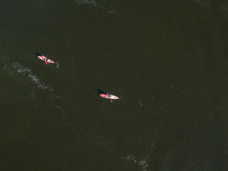 Fototapeta premium Kayak boat in the green water of the Dnieper river. Aerial drone view.
