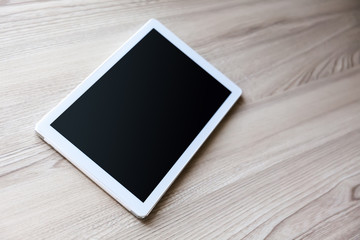 White tablet pc with empty screen on wood background