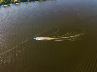 Motor boat in the Dnipro river. Sunny clear summer day. Aerial drone view.