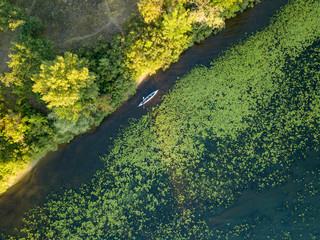 Kayak boat in the green water of the Dnieper river. Aerial drone view.
