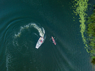 Aerial drone view. Fast motor boat in the blue water of the river.