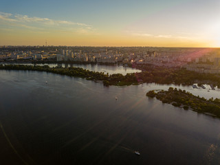 Fototapeta premium Aerial drone view. Bank of the Dnieper River in Kiev in the evening in the rays of the setting sun.