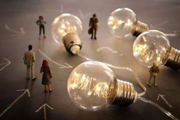 Surreal image of people looking at glowing light bulbs. Concept of finding the right idea, or...
