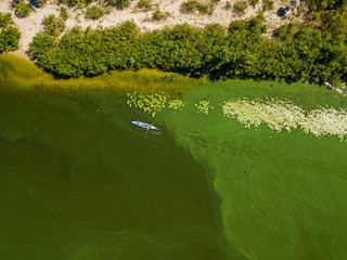 Kayak boat in the green water of the Dnieper river. Aerial drone view.