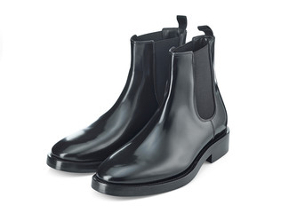 Autumn Chelsea boots made of thick glossy leather with a low heel, isolated on a white background with a light shadow. Top view at an angle.