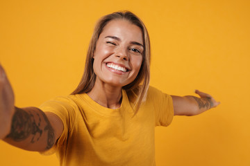 Image of young joyful woman showing copyspace and taking selfie photo