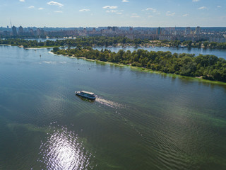 Obraz premium The boat sails along the Dnieper River in Kiev. Aerial view.