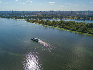 Obraz premium The boat sails along the Dnieper River in Kiev. Aerial view.