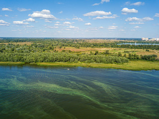Green bank of the Dnieper river on a summer sunny day. Aerial drone view.
