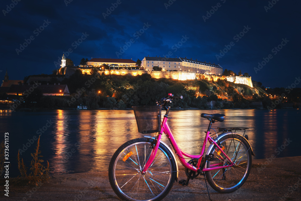 Wall mural bicycle on the novi sad embankment overlooking the petrovaradin fortress, night shot, travel to serb