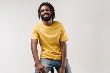 Happy african guy posing isolated over grey wall background