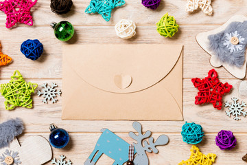 Fototapeta na wymiar Top view of envelope on festive wooden background. Christmas toys and decorations. New Year time concept