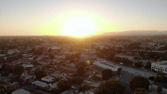 Aerial static shot over streets in Culver city neighborhood with mountains in background in Los Angeles, California, USA