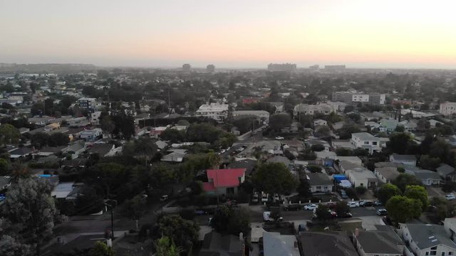 Aerial shot moving sideways over streets in Culver city neighborhood with downtown in background in Los Angeles, California, USA