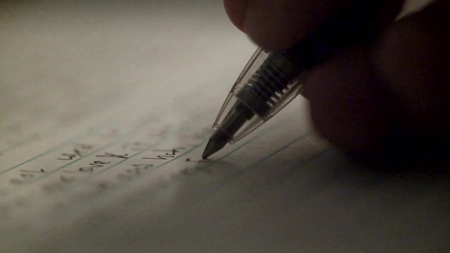 Writing a letter with a pen in the dark.