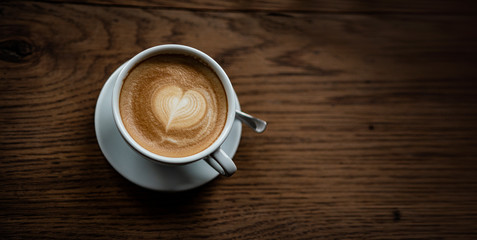 Leckere Kaffee Kreation mit Herz auf altem Holz-Tisch