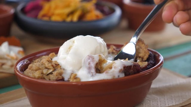 Fork mixing scoop of plant based ice cream with crumble pie. Healthy organic vegan desserts