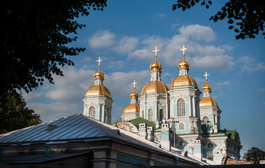 Fototapeta na wymiar Golden domes of the Orthodox Church of Nicholas in St. Petersburg against the blue sky on a Sunny day