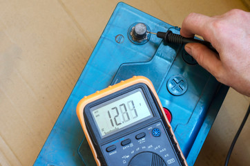 Auto electrician checks the charge quality of an auto battery.