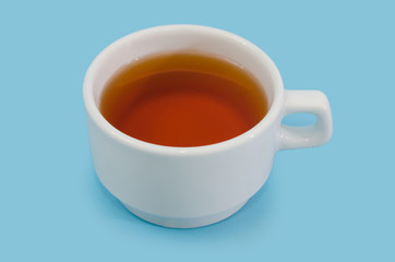 white cup with tea on a blue background. Close-up.