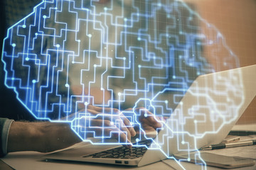Man typing on keyboard background with brain hologram. Concept of big Data.