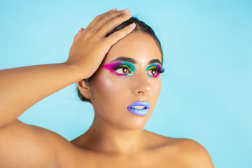 Naklejka premium Beauty portrait of female model with vivid makeup on blue background and blue lips.