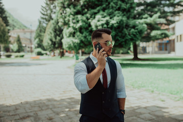 a young sexy businessman in a suit talking on smartphone