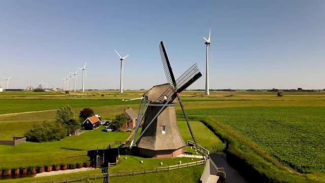 Old windmill in combination with windturbines generating clean energy.
