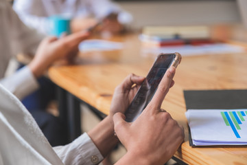 Obraz premium Close-up shot of group of people using smart phone while sitting together
